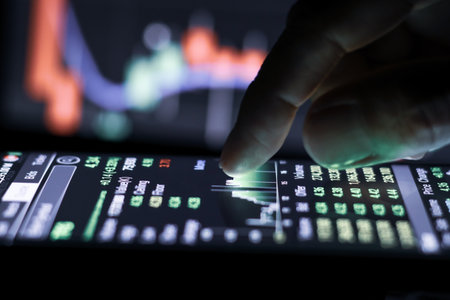Businessman finger touching screen on smartphone with stock market graph at night.の写真素材