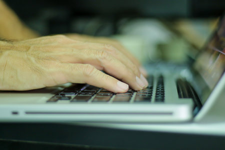 Man hands working on laptop keyboard, closeup shot.の写真素材