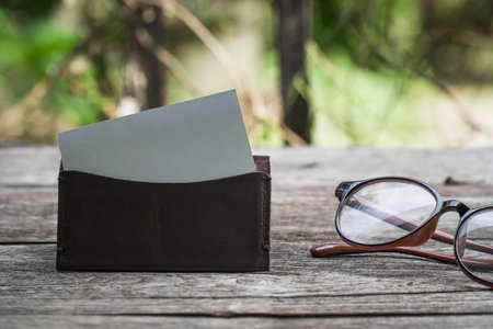 Business card mock up with card holder on old wooden table backgroundの写真素材