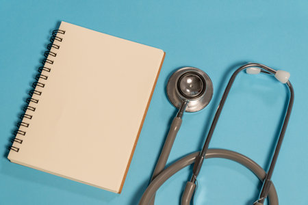 Stethoscope and notebook on blue background. Top view with copy spaceの写真素材