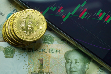 Golden bitcoin coin and smartphone on the background of the financial graphの写真素材