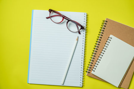 Top view Notebook with blank page on yellow backgroundの写真素材