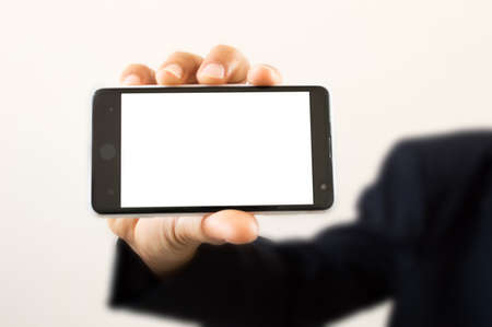 Human hand holding smart phone isolated on gray backgroundの写真素材