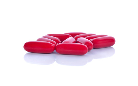 Pile of red pills isolated on white background