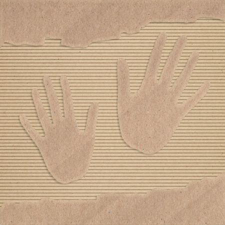 Two hand cut out on a corrugated cardboardの写真素材