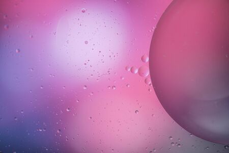 macro of oil mixed with water on colorful gradient background