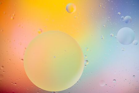macro of oil mixed with water on colorful gradient backgroundの写真素材