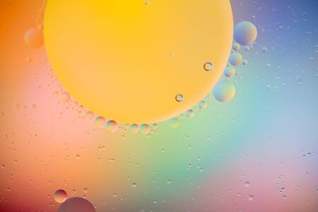 macro of oil mixed with water on colorful gradient backgroundの写真素材
