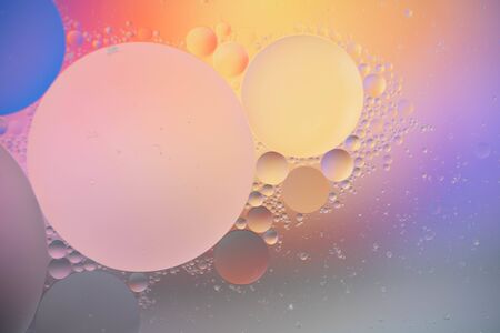 macro of oil mixed with water on colorful gradient backgroundの写真素材