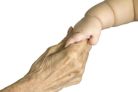 hand of a young baby touching old hand of the elderlyの写真素材