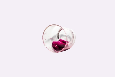 Glass of wine fall on the tableの写真素材