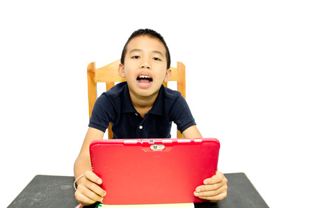 Boy hold a tablet on a deskの写真素材