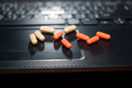 many pills and computer keyboardの写真素材