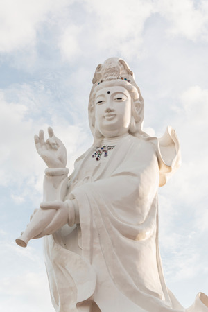 Guanyin Buddha statue on blue skyの写真素材