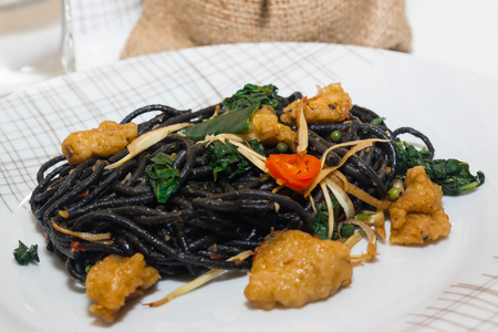 Black spaghetti with prawns on white plateの写真素材