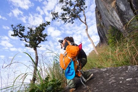 female photographer taking a picture on Mountainの写真素材