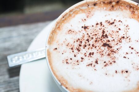 hot coffe on coffee cup on wood table