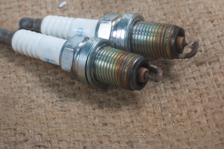 Old Spark plugs isolated on Sackcloth material background