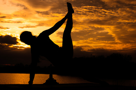 Women are playing yoga at Reservoir area with Sunsetの写真素材