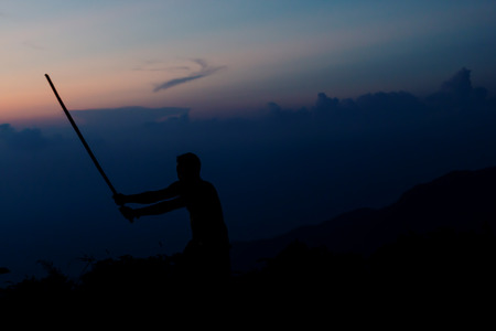 Shadow of Samurai with sword practice fencing and beautiful mountain view after Sunsetの写真素材
