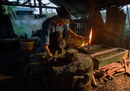 Professional Blacksmith at work is Hit the iron by a hot metal With fire