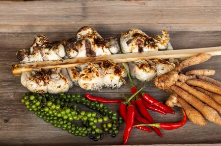 Group of frog grilled with spices  isolate on wood background