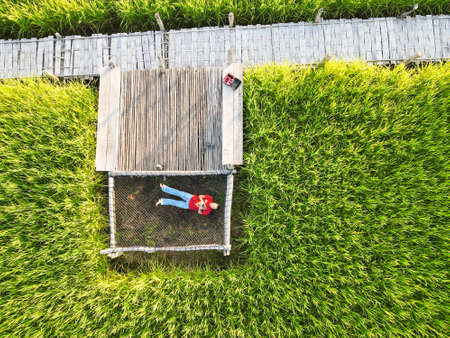 24 October 2020 in NAN: man sleeping on a hammock in a rice fieldのeditorial素材