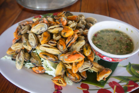 Steamed mussels with spicy seafood sauce on white dish, Thailandの写真素材
