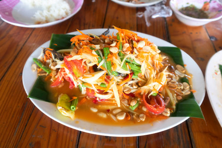 Thai spicy papaya salad with rice on the wooden table.の写真素材