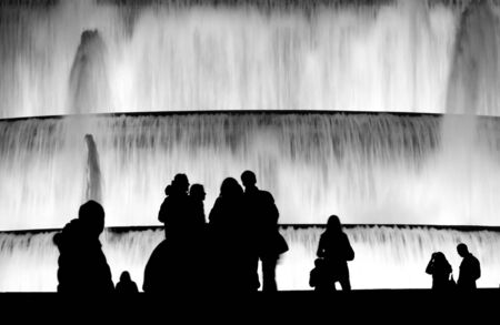 Silhoutte of tourist enjoying the evening beside fountain in Barcelona.