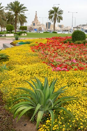 Beautiful flower bed with blooming colorful flowers infront of spiral mosque Dohaの写真素材