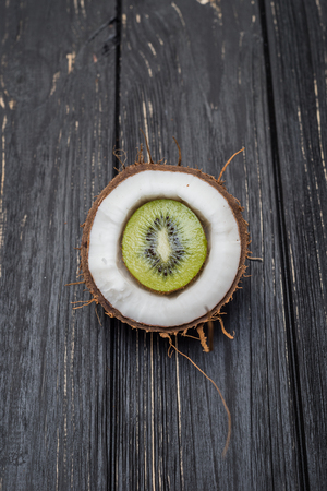 Coconut and kiwi within on grey wooden tableの写真素材