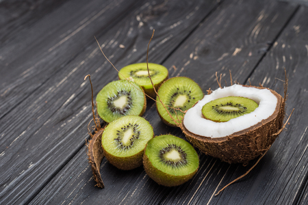 Coconut and kiwi within on grey wooden tableの写真素材