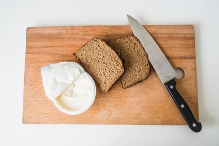 bread and butter with knife on chopping board