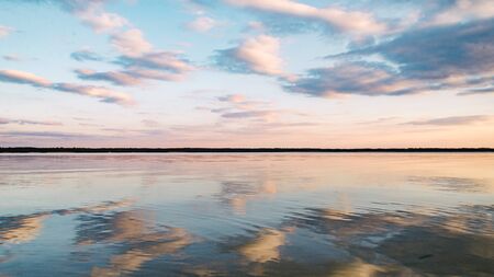 sunset at dead-calm lake with sky reflection water.の写真素材
