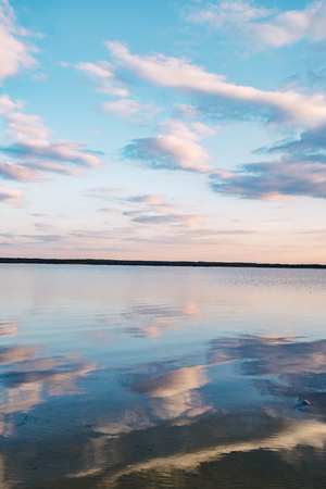 sunset at dead-calm lake with sky reflection water.の写真素材
