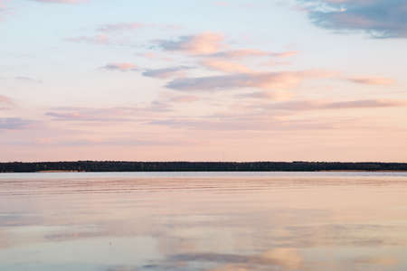 sunset at dead-calm lake with sky reflection water.の写真素材