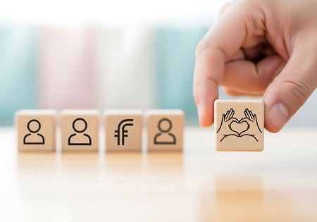 Hand places wooden block with heart hands symbol next to people and currency icons wooden blocks placingの素材