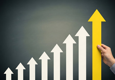 Hand placing yellow arrow on graph of white upward arrows growth successの素材