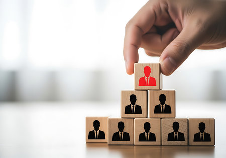 Hand places red silhouette person cube atop pyramid of black silhouette person cubesの素材