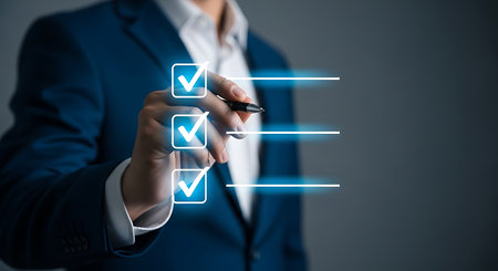 Person in blue suit marking checklist with pen on digital screen to do list check markの素材