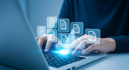 Hands typing on laptop with digital document icons floating above technology fileの素材
