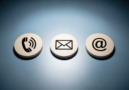 Three circular wooden tokens with contact icons phone email at symbol phone iconの素材
