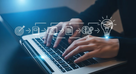Hands typing on a laptop keyboard with a blue digital flowchart overlay showing a target book brain and lightbulb idea.の素材