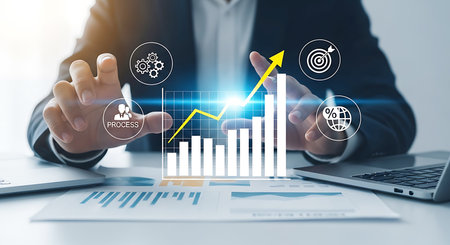 Hands in a suit interact with a glowing digital bar graph and upward yellow arrow, surrounded by business icons.の素材
