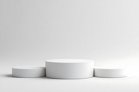 Three white cylindrical podiums of varying heights are arranged on a plain light gray surface with a soft gradient background.の素材