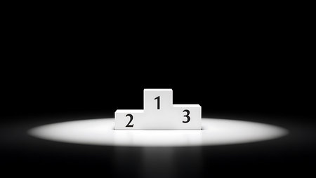 A white three-tiered podium with numbers 1 2 3 is illuminated by a bright spotlight against a dark background.の素材