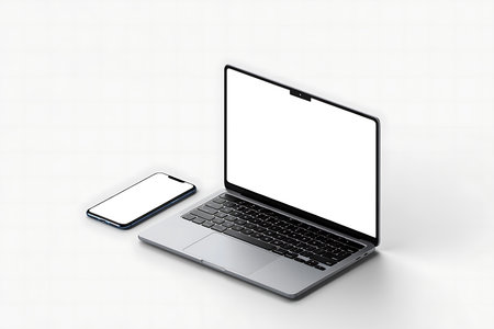 Silver laptop and smartphone with blank white screens are positioned on a clean white surface.の素材