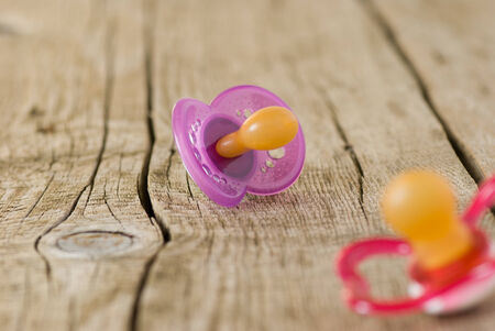 Baby's pacifier on old wooden tableの写真素材