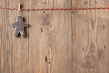 Christmas decoration hanging on clothesline on old wooden backgroundの写真素材